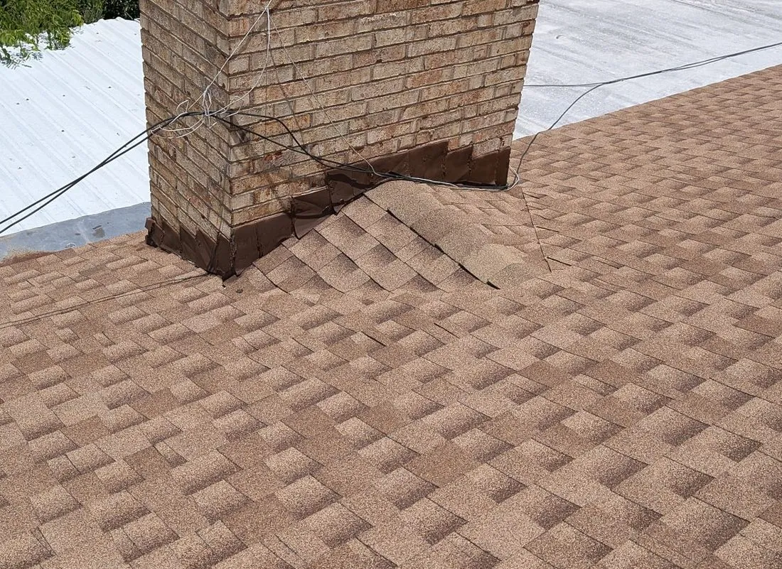 Chimney cricket on a Central Texas roof, the small peaked structure behind the chimney that splits water around it