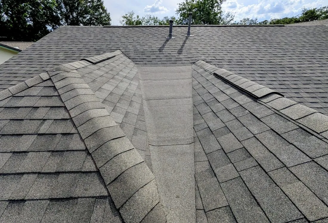 Roof peaks on a Central Texas home showing the ridge line where a continuous ridge vent runs