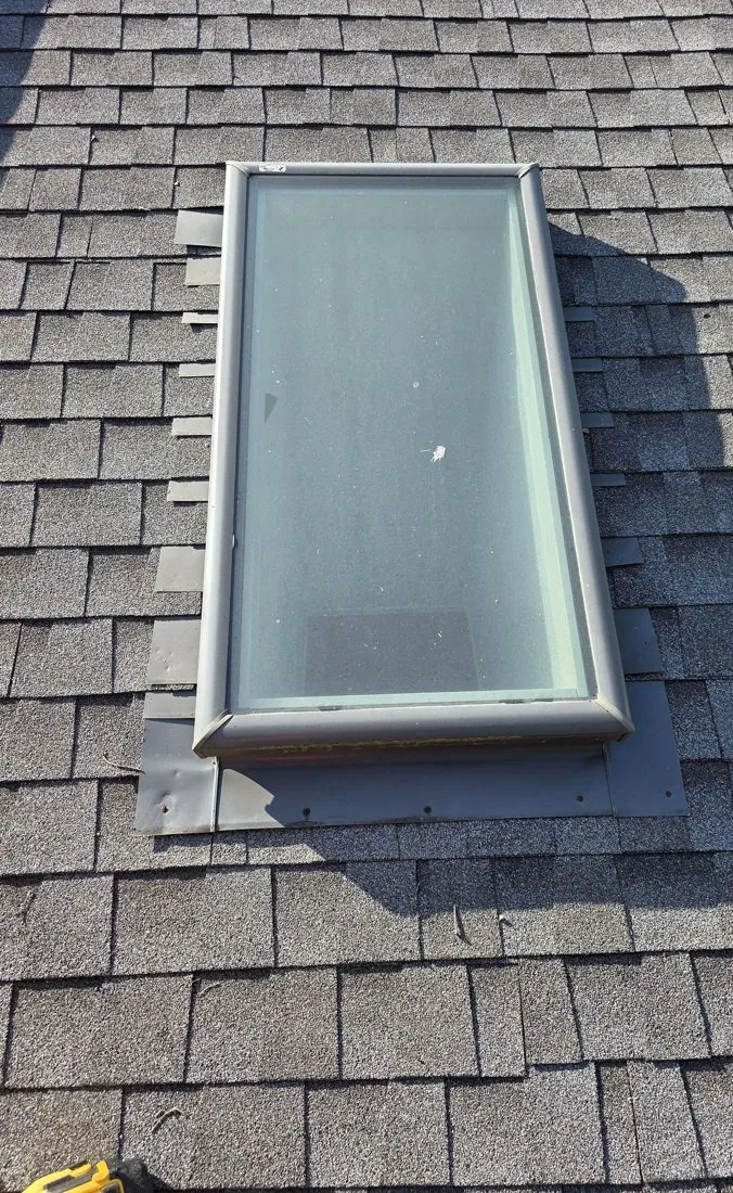 Curb-mounted skylight on a Central Texas roof with step flashing visible along its side