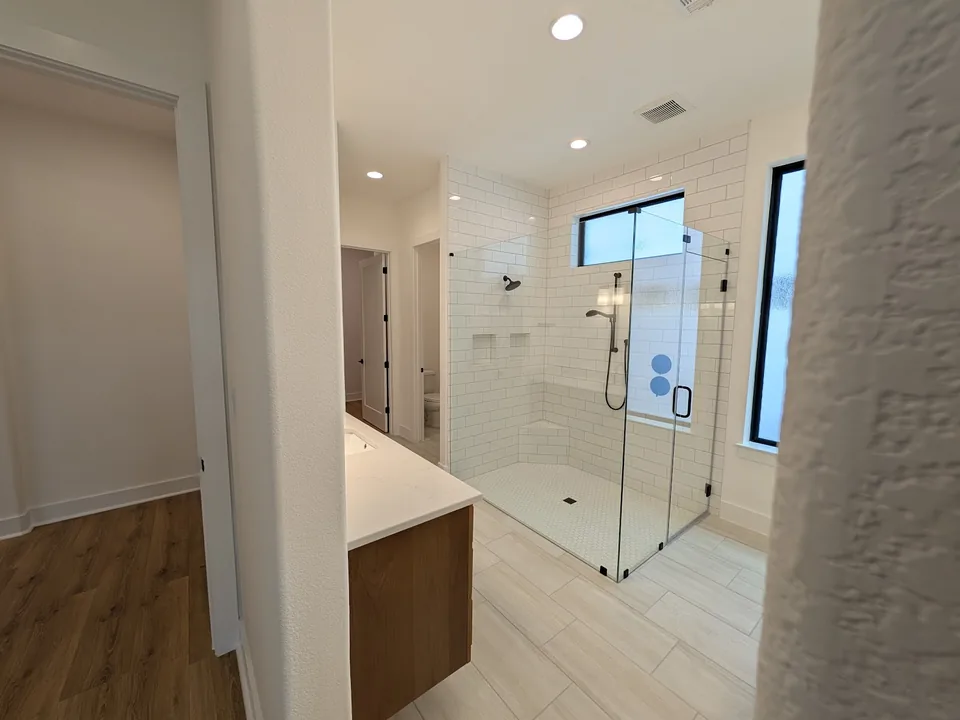 Bathroom with painted walls, glass shower and wood vanity