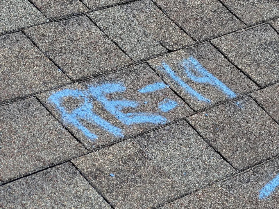 Blue chalk writing on shingles marking a test area count