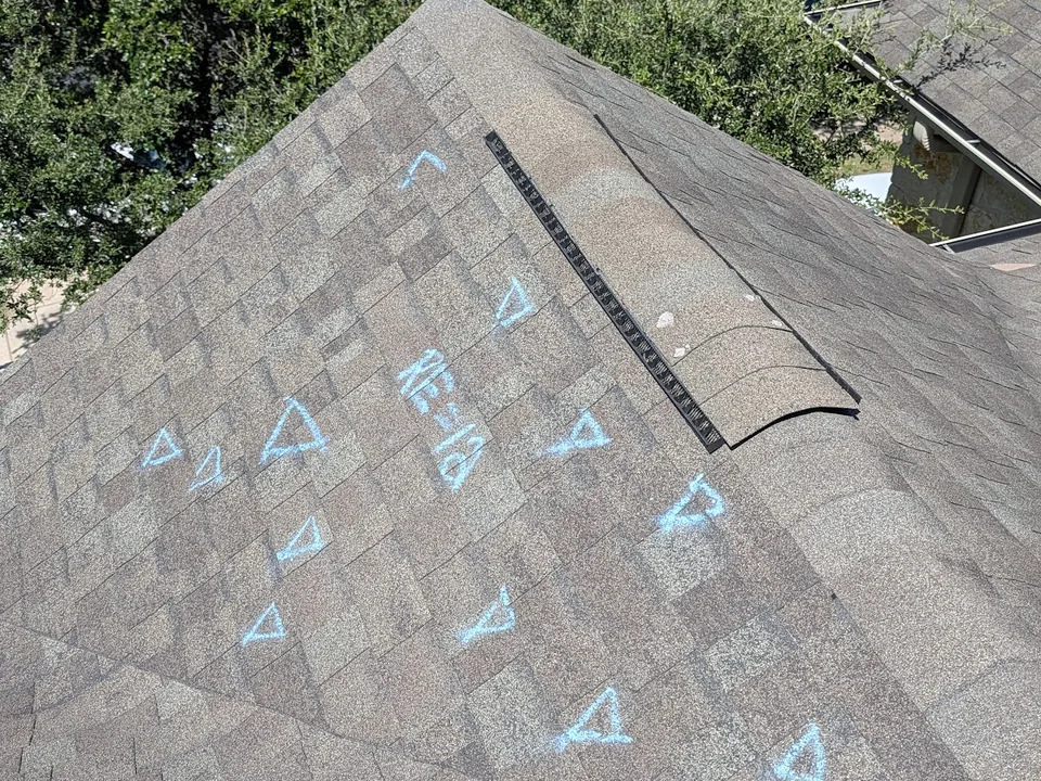 Blue chalk marks on a shingle slope below a ridge vent