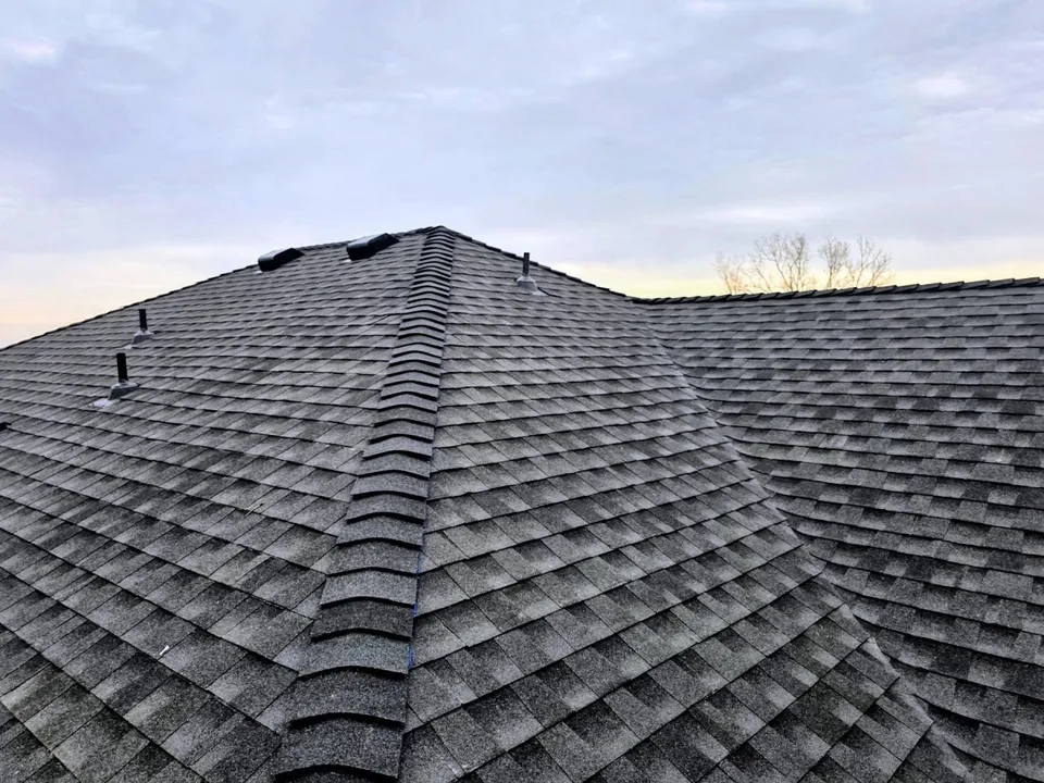 Hip and ridge cap shingles on a dark architectural shingle roof