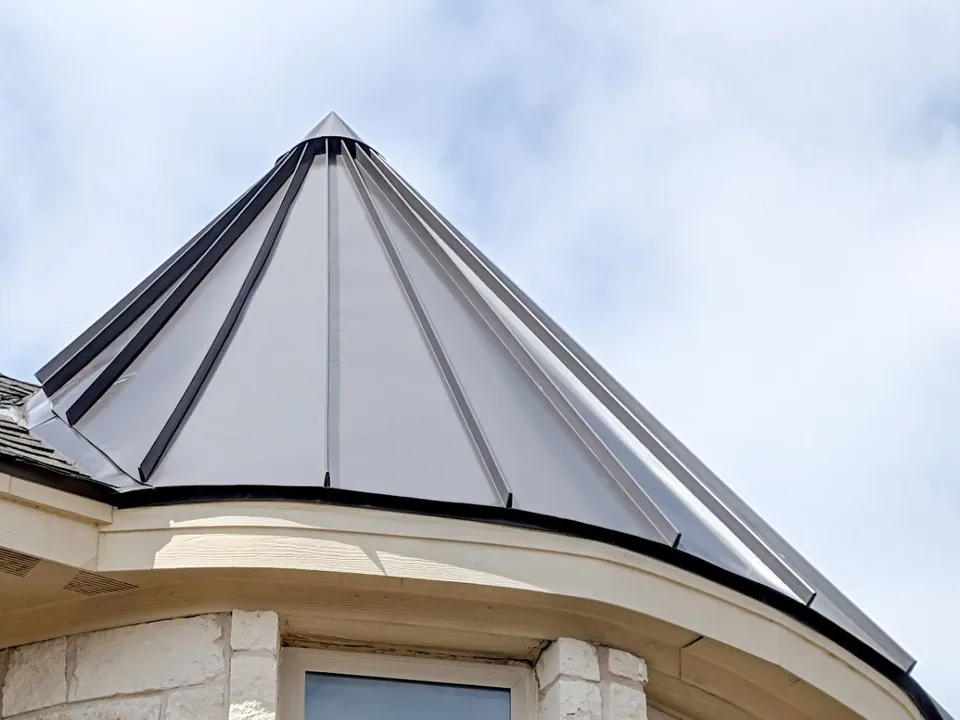Standing seam metal turret roof seen from the ground