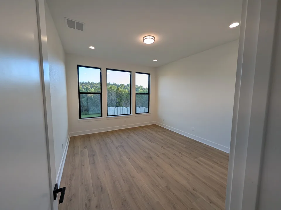 Empty room with painted walls and trim and black-framed windows