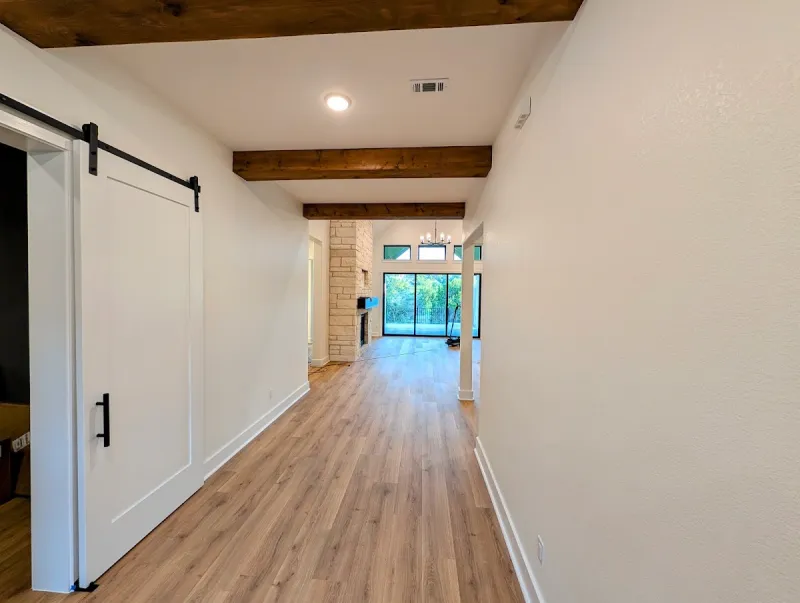 Finished hallway and open living area after custom interior painting in Georgetown, Texas.